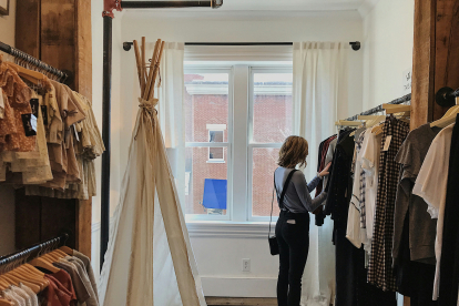 mujer mirando ropa en una tienda de moda