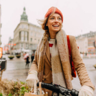 Photo of a smiling young woman running errands on her bicycle all over the cit