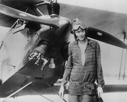 Amelia Earhart delante de su avión llamado 