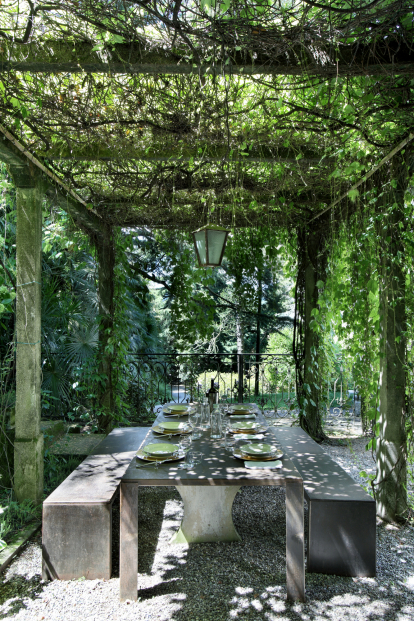 Un jardín de ensueño. Bajo la parra, mesa y banquetas de sólida estructura para comer al aire libre en medio de la naturaleza.