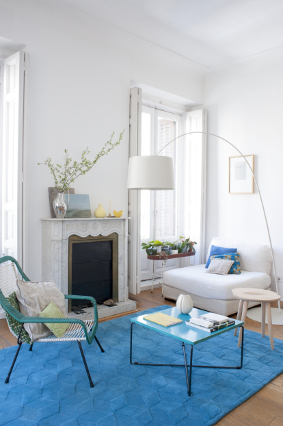 El salón ha pasado por diferentes épocas cromáticas y ahora vive su etapa azul. La alfombra es uno de los modelos que creó Rohner para Bolia en 2013. Junto a las orquídeas de la ventana se encuentra uno de sus rincones favoritos.